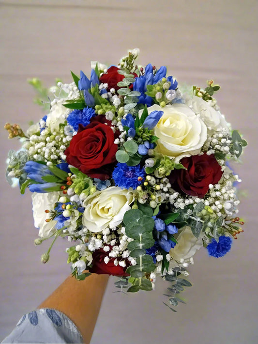 white and red roses with touch of blue coloured flowers